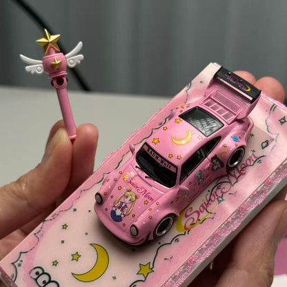 Pink toy car with cartoon design held by a hand