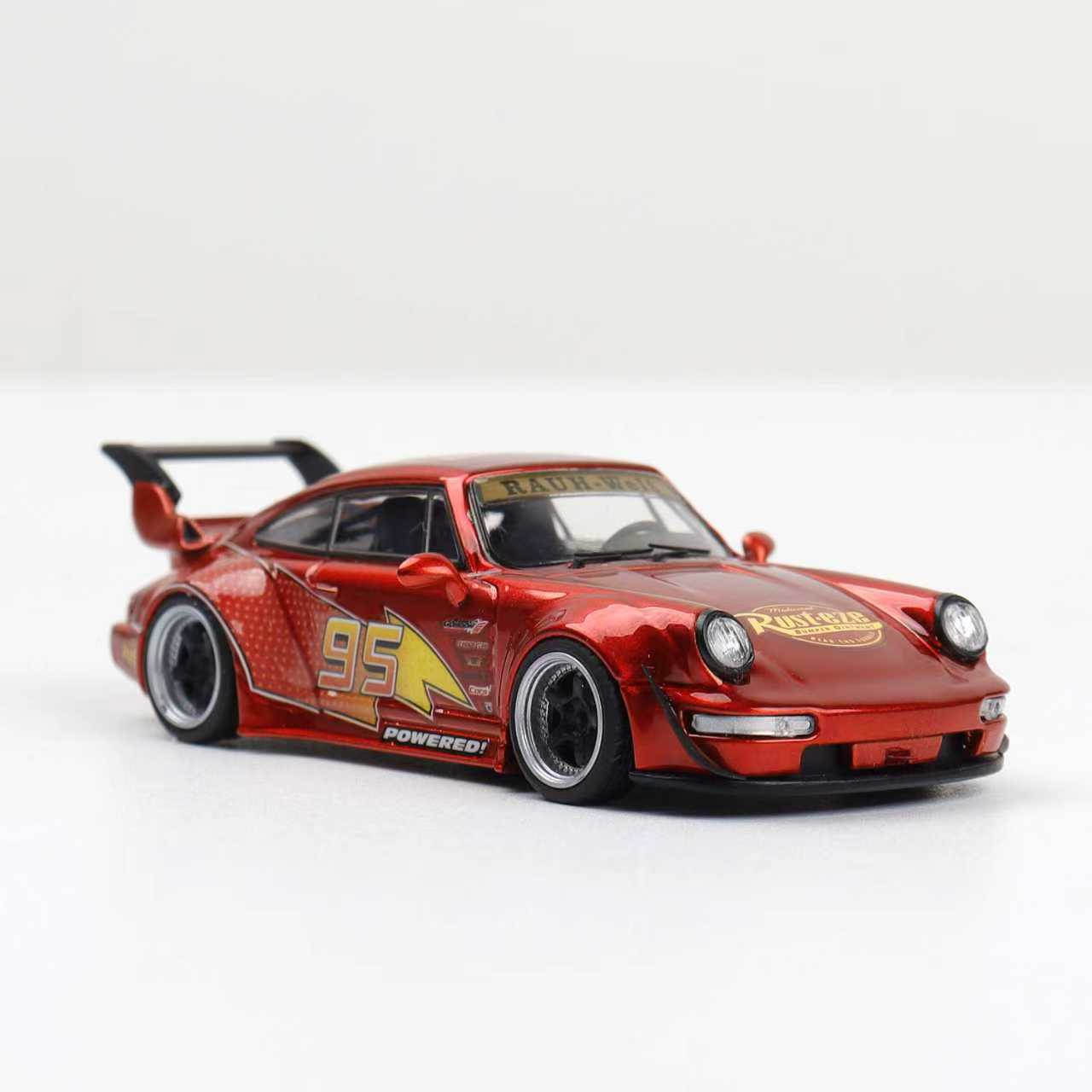Red model car with racing decals on a white background