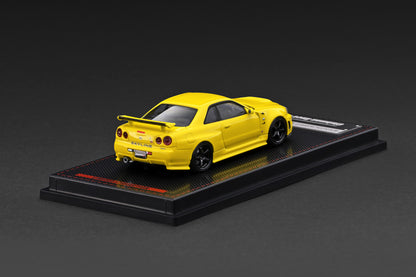 Yellow sports car model on a black display stand against a dark background