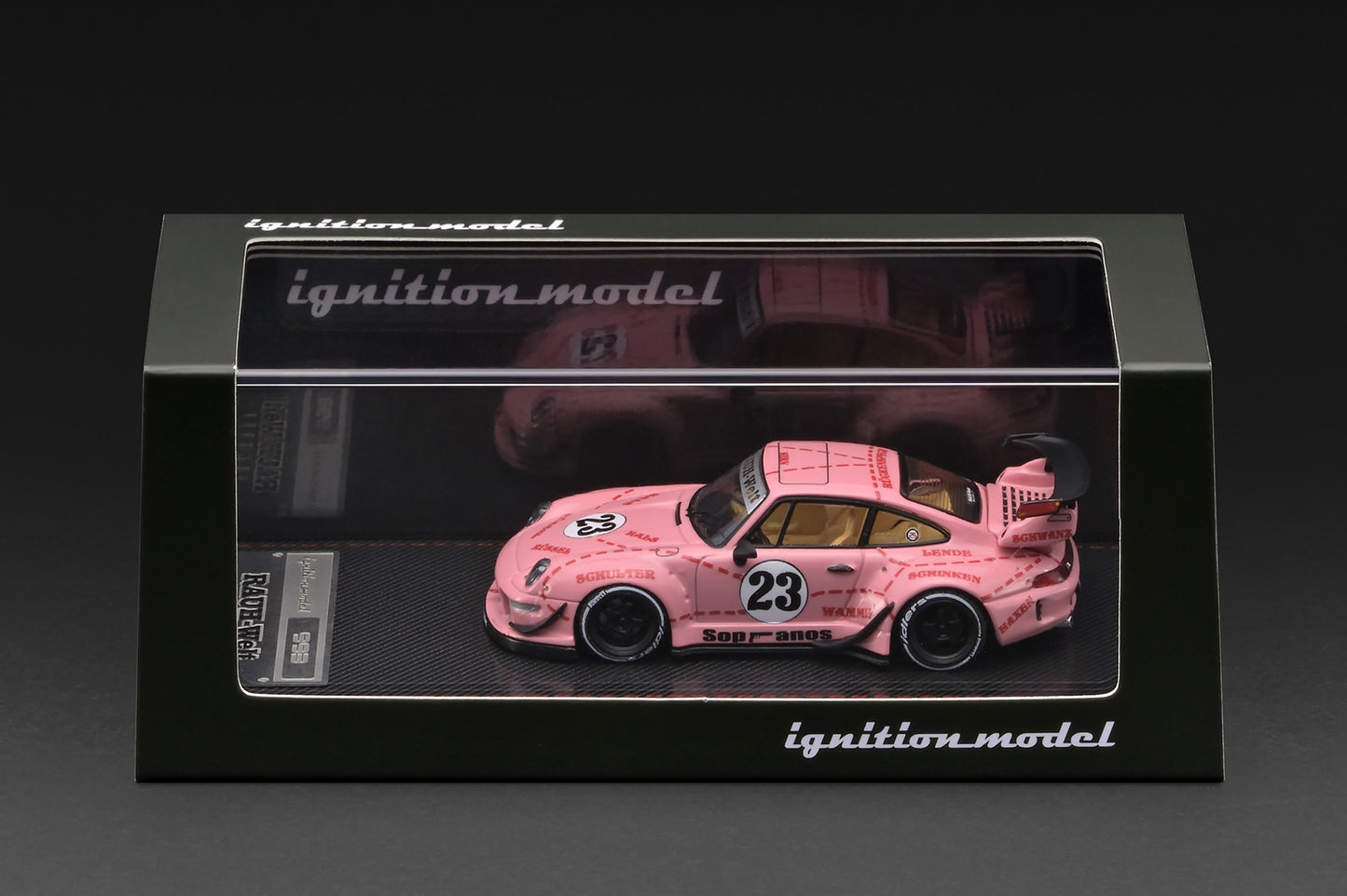 A pink model race car displayed inside a black presentation box with a clear front window. The car has the number 23 on the side and is branded with 'ignition model' on the box.