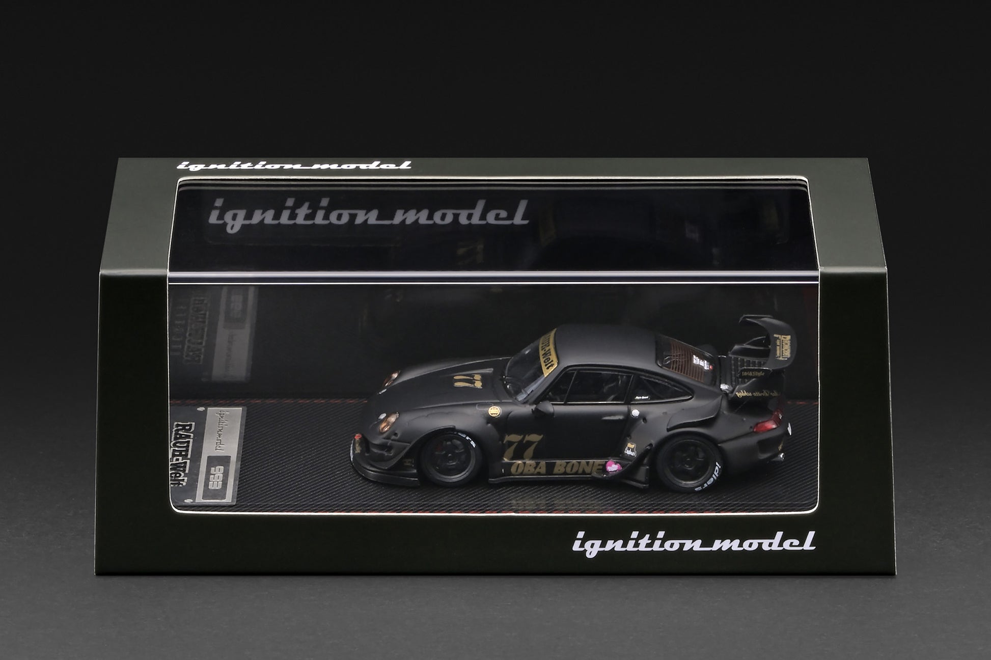 A 1:64 scale model car of the 1999 Toyota 993 RWD Nismo GT1, driven by Ori Bono, displayed inside its black Ignition Model packaging box against a dark background.