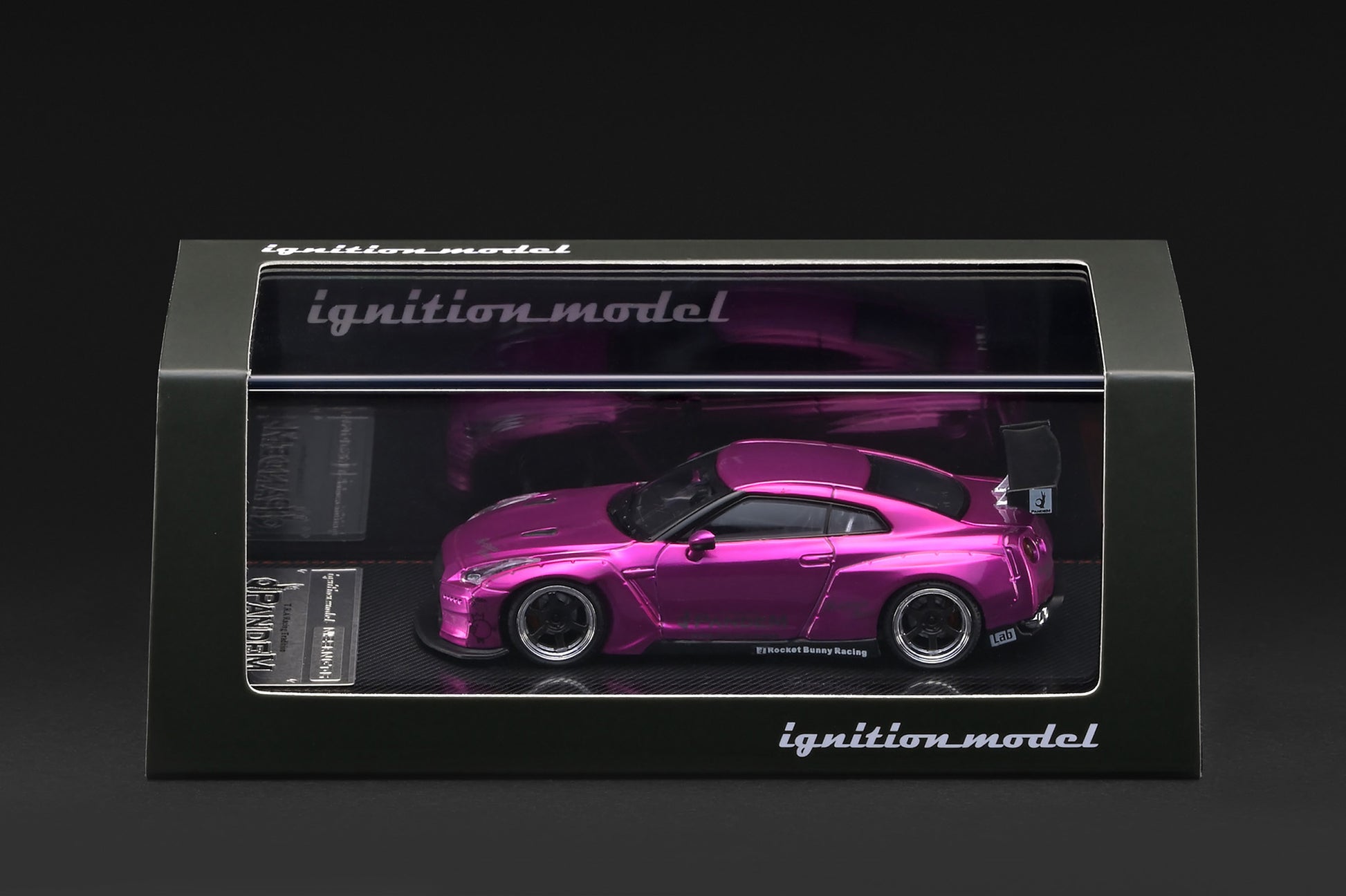 A pink Nissan GT-R model car displayed inside a black windowed box with the brand name 'ignition_model' visible on the packaging.