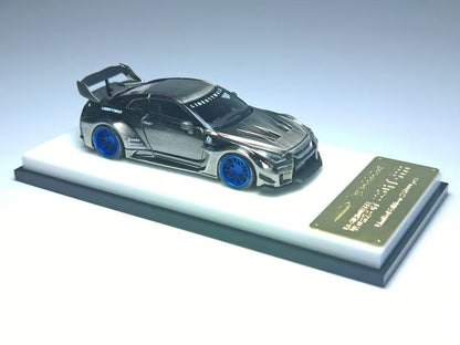 Metallic model car on a stand with a plaque on a gray background
