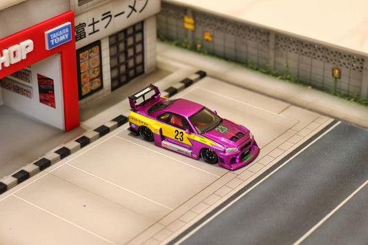 Model car with purple and yellow design on a miniature street scene with a store in the background.