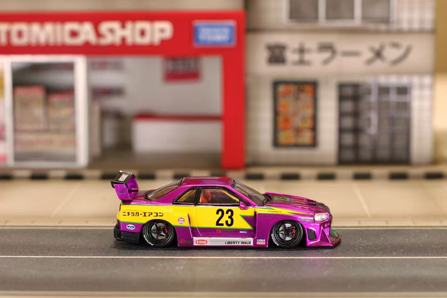 Model car with purple and yellow design on a miniature street background