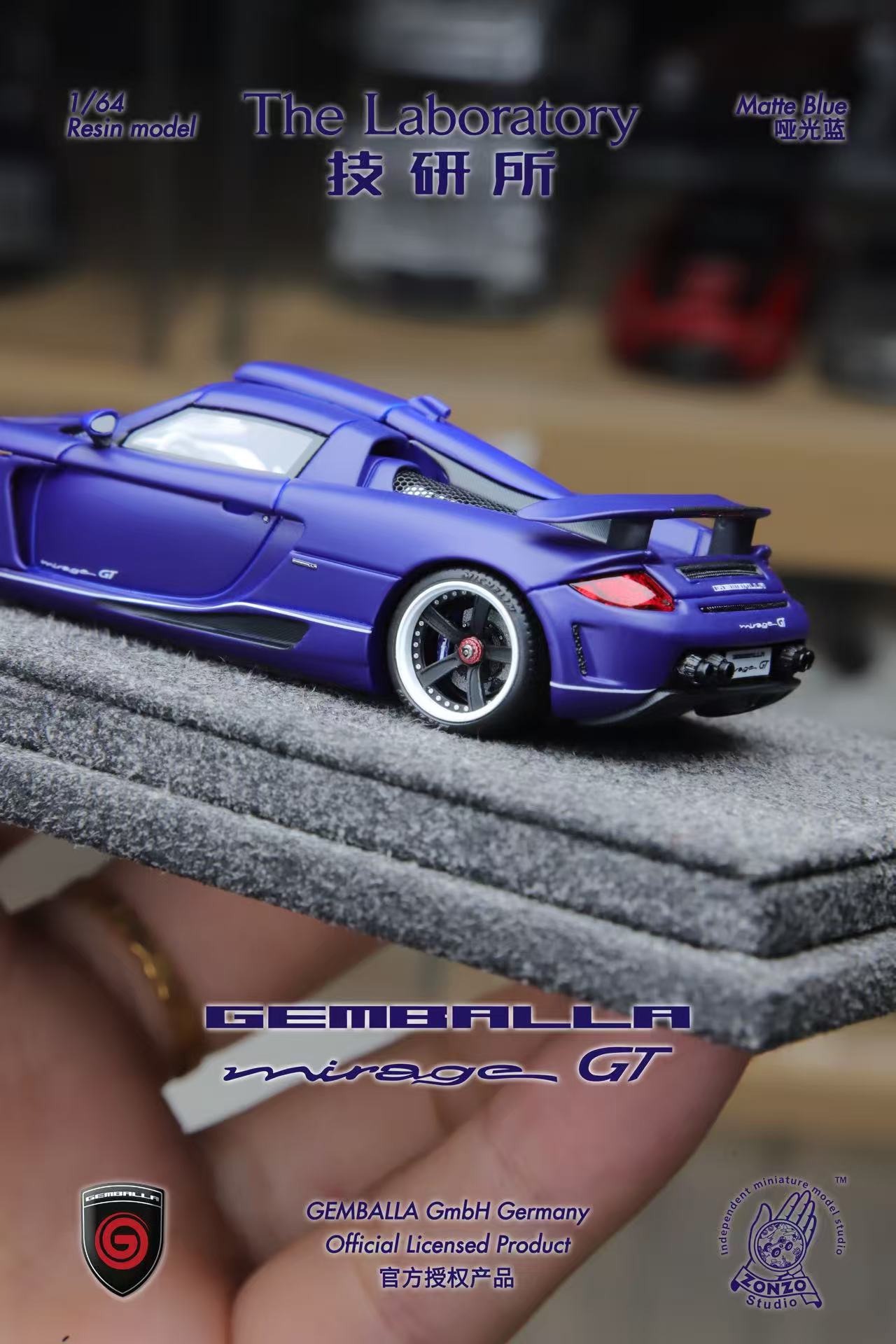 Blue model car on a gray display stand with 'GEMBALLA' branding.