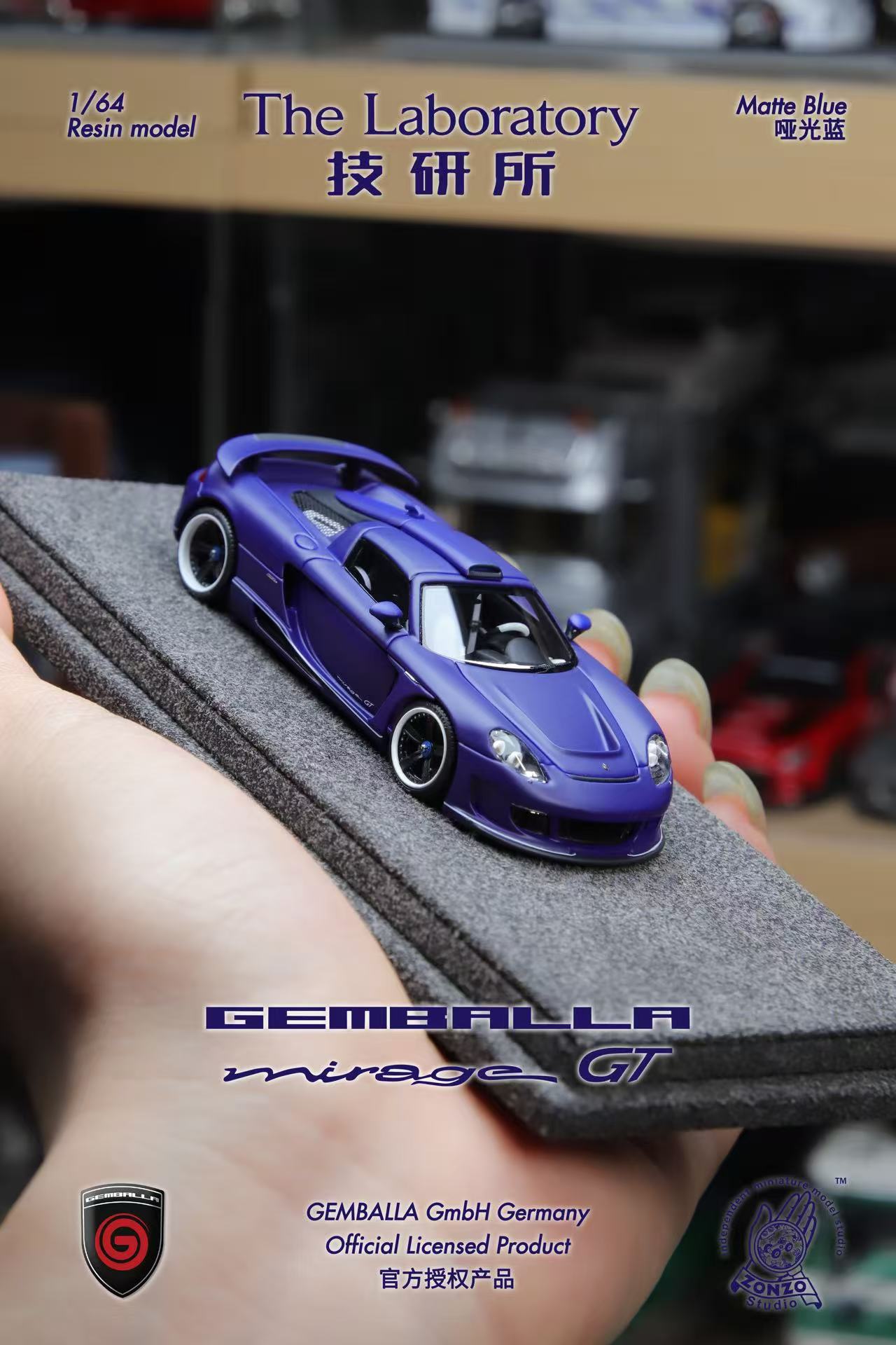 Blue model car on a gray surface with 'GEMBALLA' branding