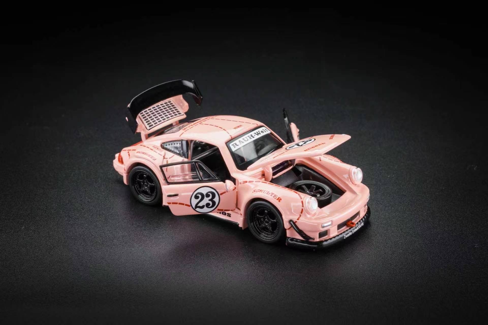 A pink toy model car resembling a classic Porsche race car, shown with its doors open on a dark studio background.