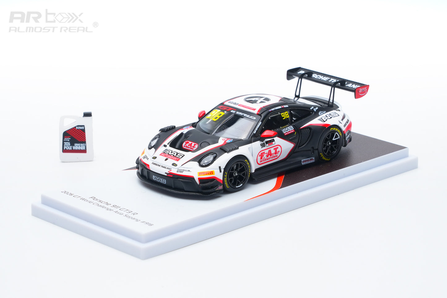 A 1:64 scale model of a Porsche 911 GT3 race car, specifically the Ruckstuhl Racing #24 car, displayed on a white and black stand alongside a small bottle of ARbox Almost Real motor oil on a white background.