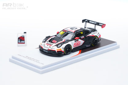 A 1:64 scale model of a Porsche 911 GT3 race car, specifically the Ruckstuhl Racing #24 car, displayed on a white and black stand alongside a small bottle of ARbox Almost Real motor oil on a white background.