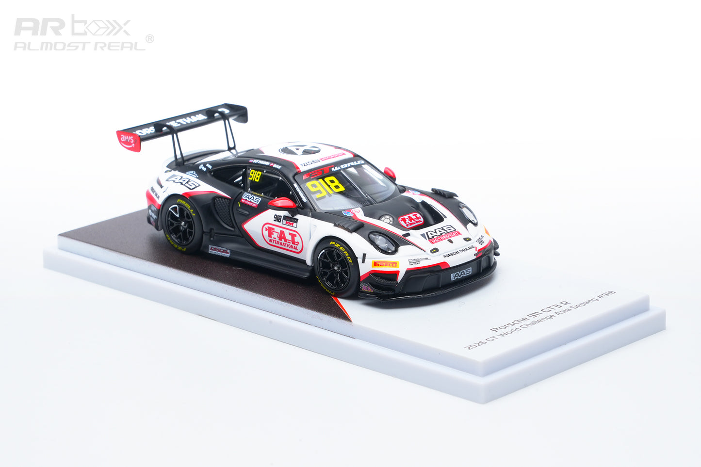 A 1:64 scale model of a Porsche 911 GT3 race car, specifically the 2024 Racing Team livery, displayed on a white and brown base against a white background.