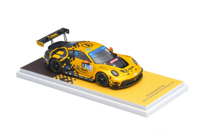 Yellow Porsche 911 race car model on a white platform with a checkered pattern