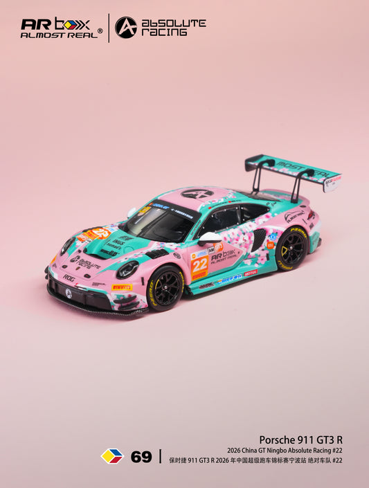 A die-cast model of a 2026 Porsche 911 GT3 R race car by Absolute Racing, featuring a pink and teal livery with sponsor decals, displayed on a solid pink background.