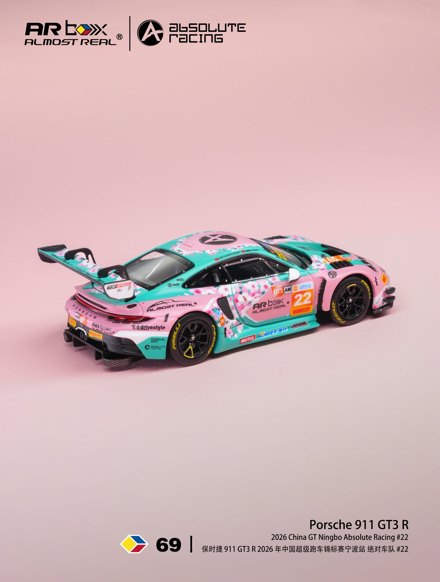 A pink and teal Porsche 911 GT3 R race car with detailed graphics and sponsor logos, displayed on a soft pink background. The image includes branding for AR BOX / ALMOST REAL and Absolute Racing, along with model number 69 and product details at the bottom.