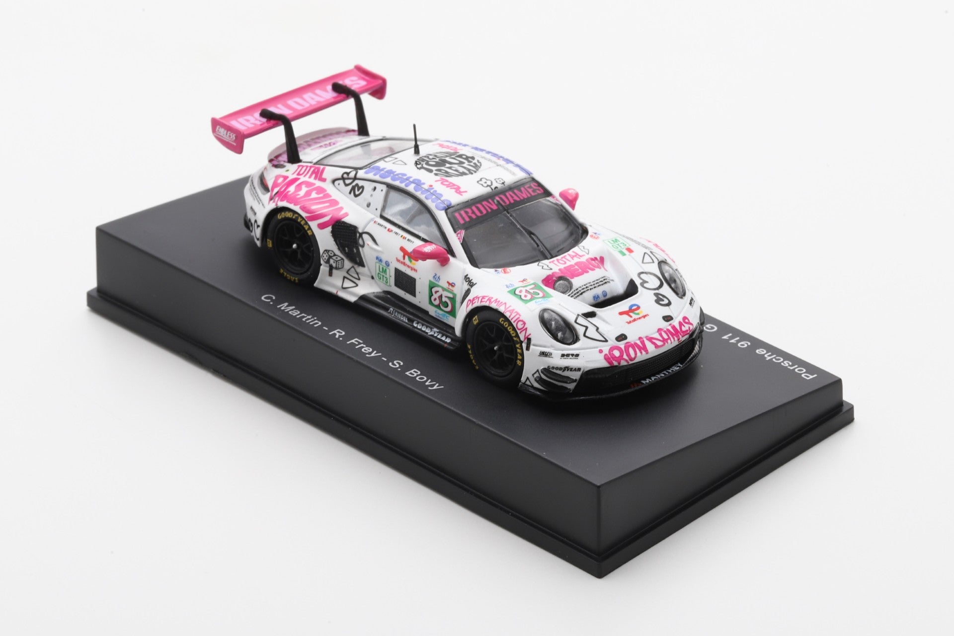 Model race car on a black stand, featuring a white body with vibrant pink and black graffiti-style designs and logos, exuding a fun, energetic vibe.