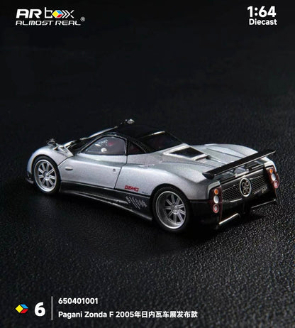 A silver Pagani Zonda F 1:64 scale diecast model by Artbox Almost Real, showcasing detailed design against a dark textured background.
