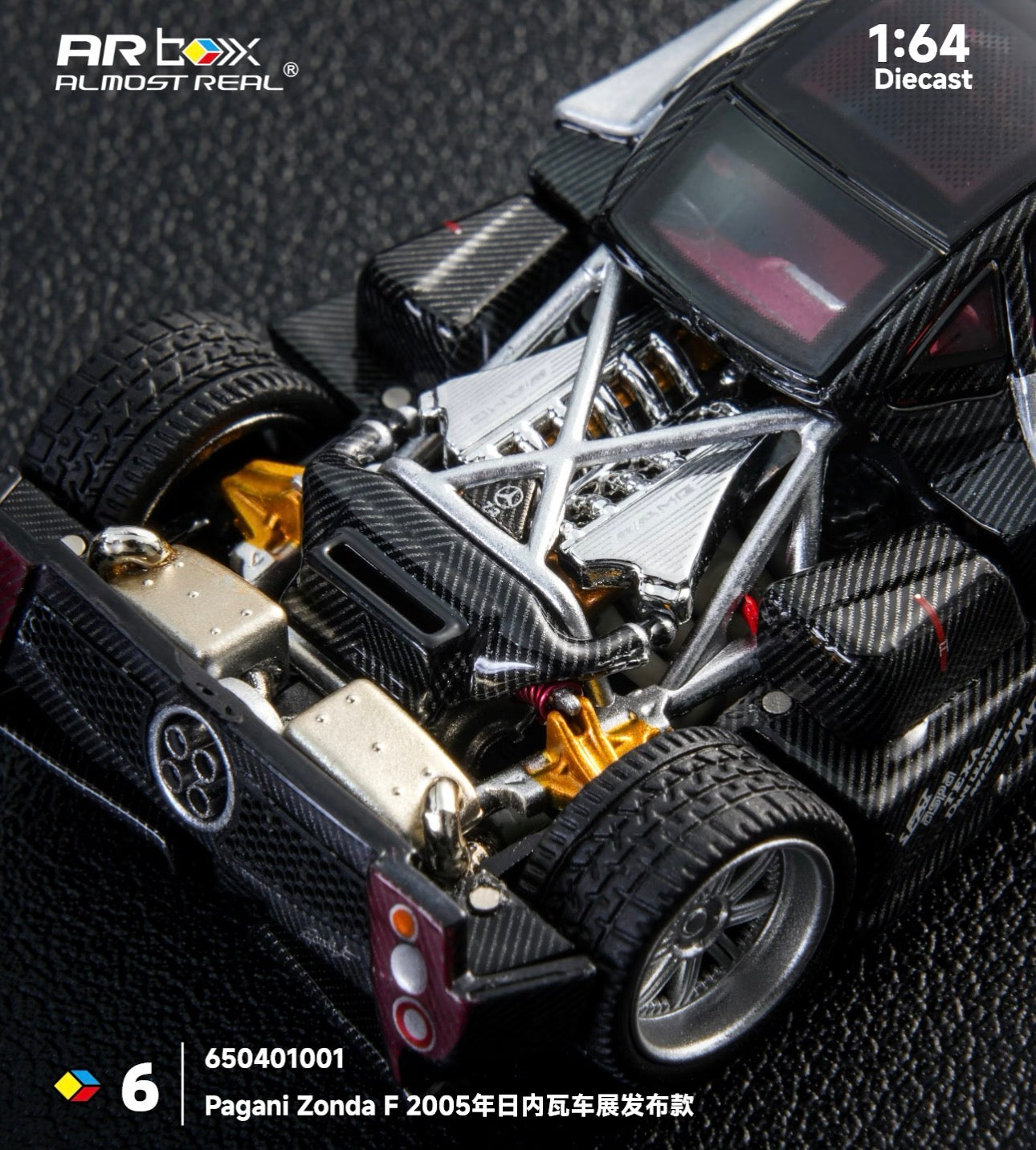 Close-up of a 1:64 scale diecast model of a Pagani Zonda F, showcasing detailed engine components, black carbon fiber texture, and intricate design.