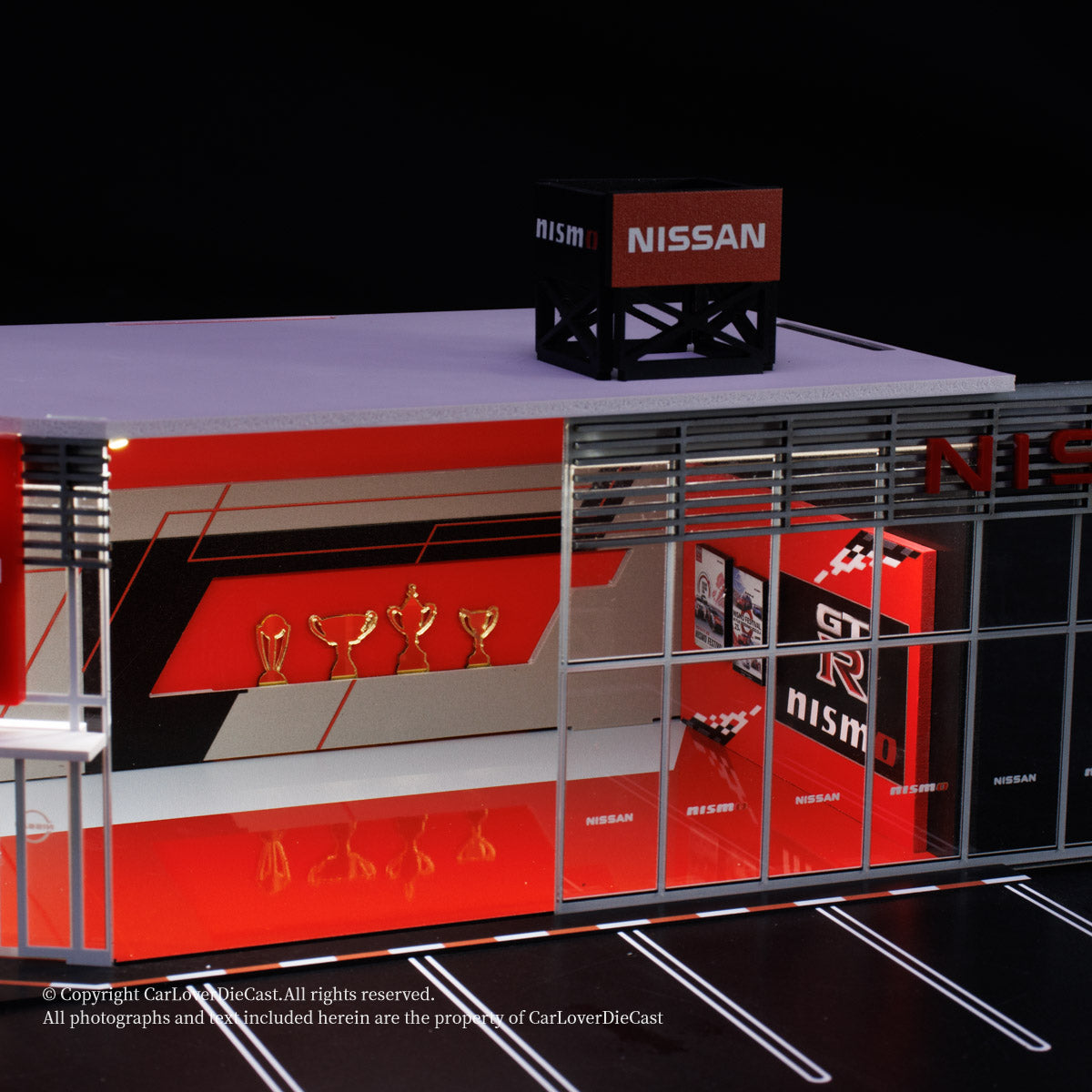 Model of a Nissan garage with various items on a black background