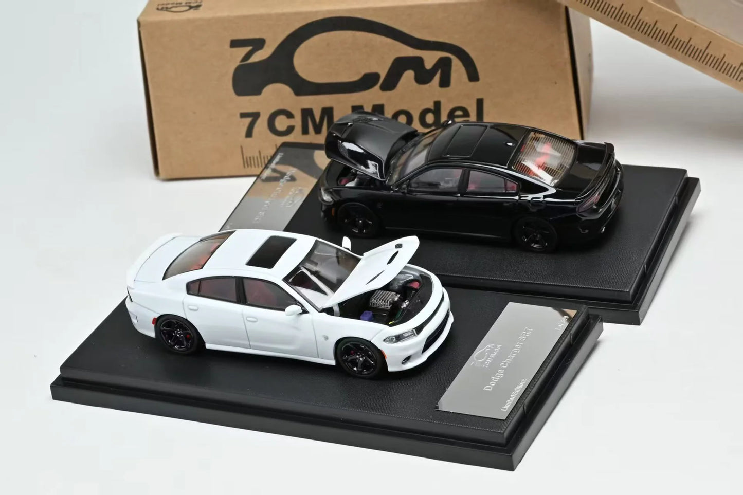 Two model cars on display stands with a '7CM Model' box in the background.