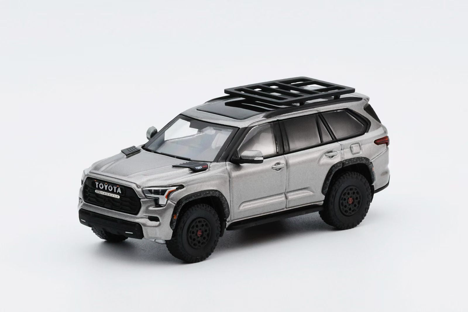 Model toy car of a Toyota SUV with roof rack on a white background