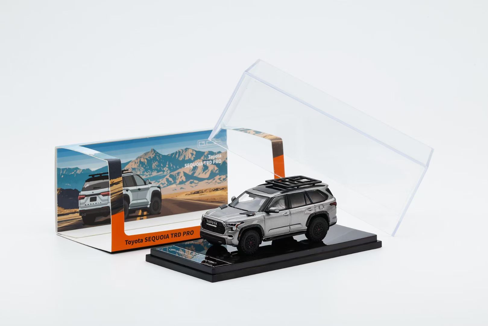 Model car of a Toyota SUV in a clear display case with a scenic background