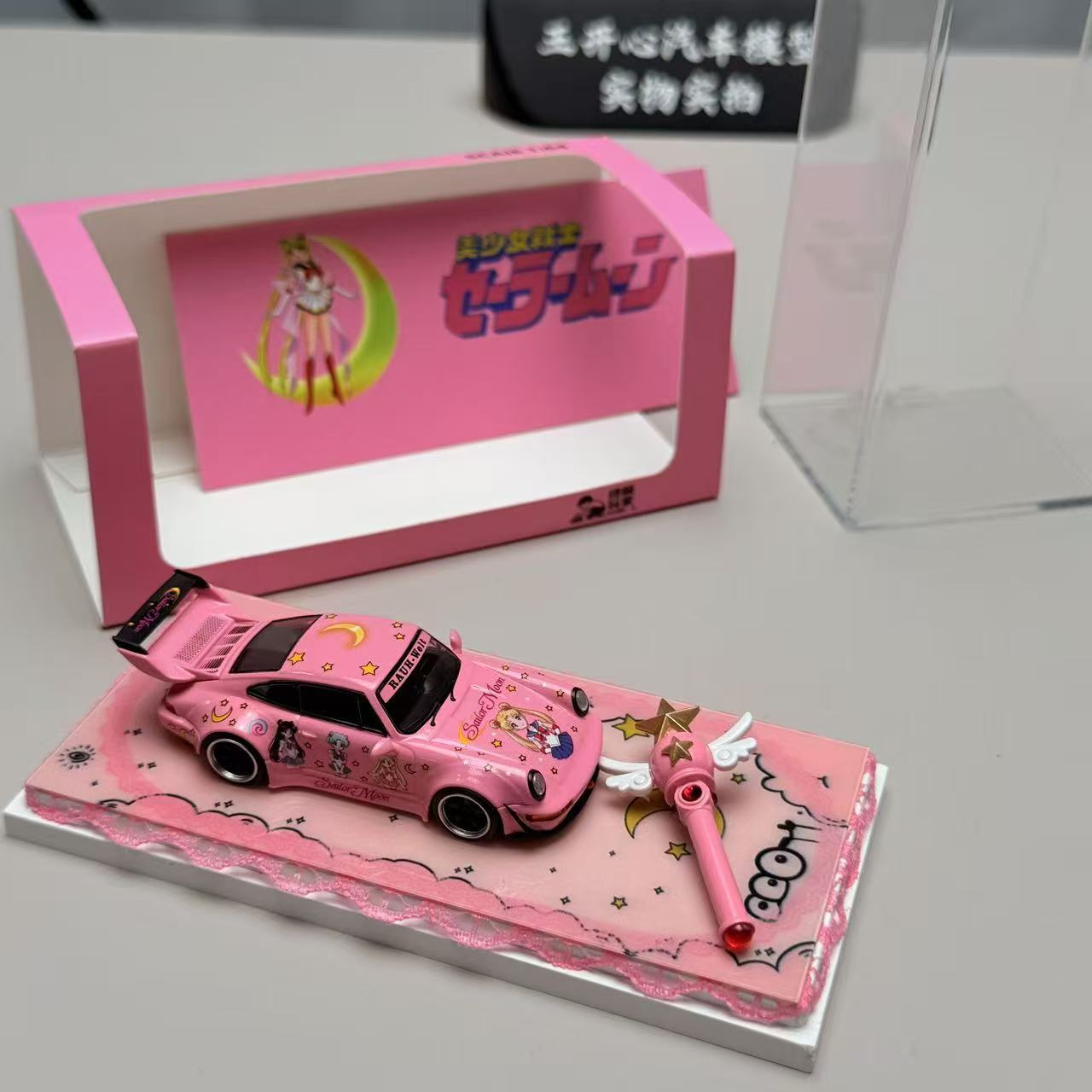 Pink toy car with star design on a pink stand, featuring a transparent display case.