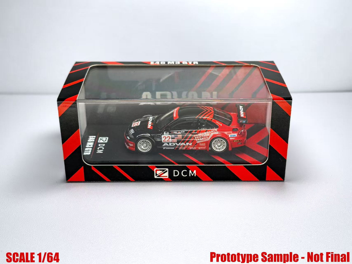 Model car in a transparent box with red and black design on a white background