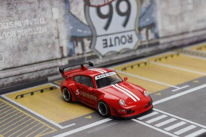 Red sports car model with 'Supreme' branding on a miniature road with Route 66 sign in the background.