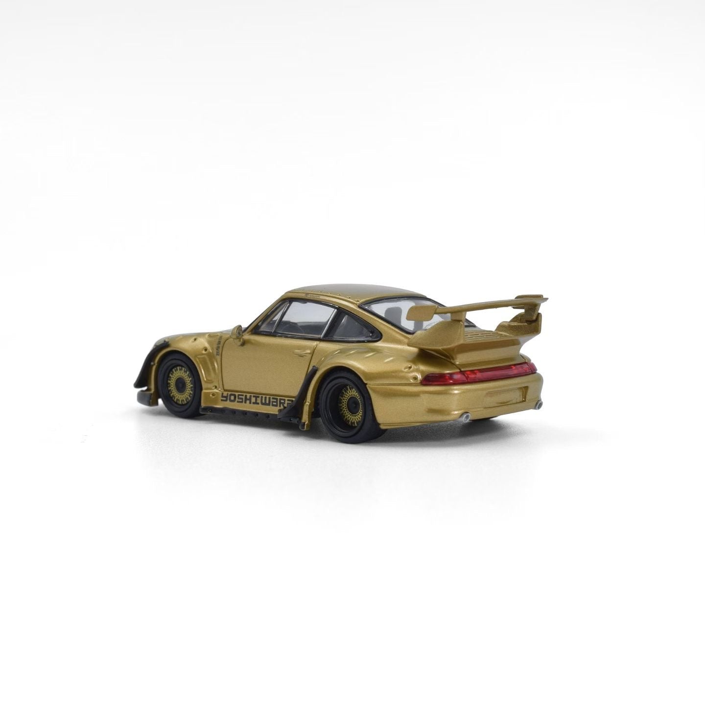 Gold model car with a large rear wing on a white background