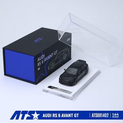 ATS 1:64 scale model car of the Audi RS 6 Avant GT, shown in a black finish on a clear display base next to its black and blue packaging box.