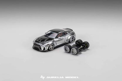 A miniature model of a silver and black sports car displayed next to its detached black wheels on a neutral gray gradient background. The brand name 'Aurelia Model' is visible at the bottom.
