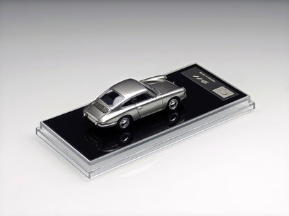 A metallic silver diecast model car displayed on a black base with a clear acrylic cover, photographed on a clean light gray studio background.