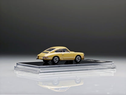 A miniature model of a classic yellow Porsche 911 car displayed on a clear acrylic stand with a black base, set against a dark gray studio background.