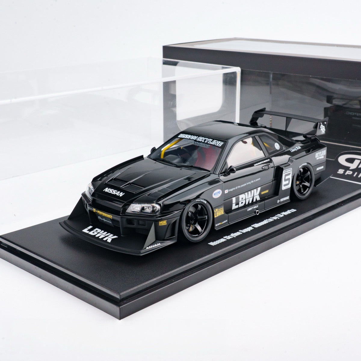 Black model car on a display stand with visible branding