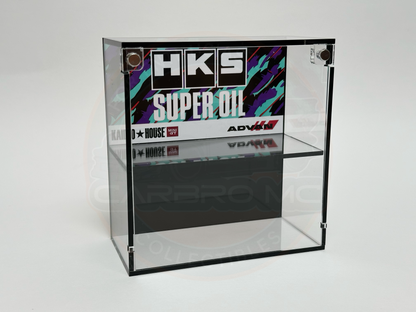 A clear acrylic display case with a black base, labeled with 'HKS Super Oil' branding on the front.