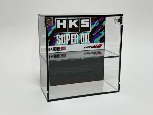 A clear acrylic display case with a black base, labeled with 'HKS Super Oil' branding on the front.