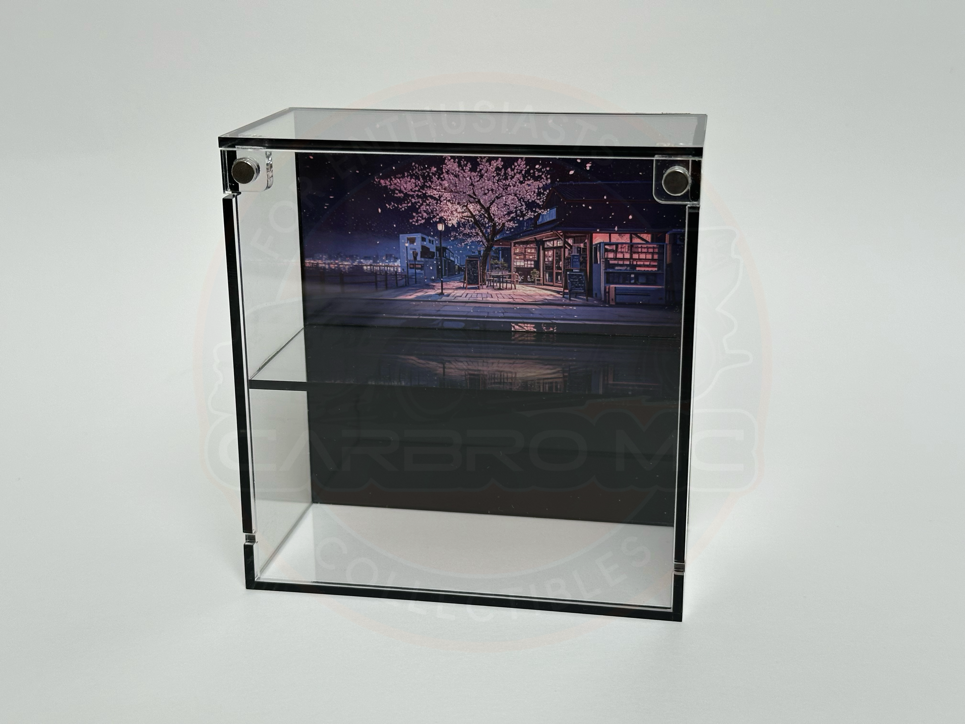 A display case featuring a 1/64 scale model with a Japanese Sakura theme, including a building and a car.