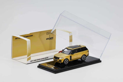 Yellow model car in a clear display case with a gold box on a white background