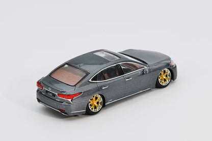 Model car with gold wheels on a white background