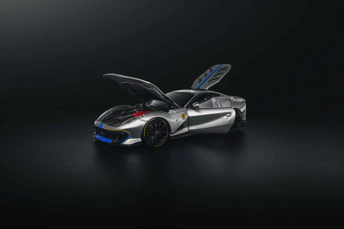 GLAMCRAFT 1:64 Ferrari 812 Competizione Silver with Blue Stripes diecast model with opening hood, door and rear hatch, front three-quarter view