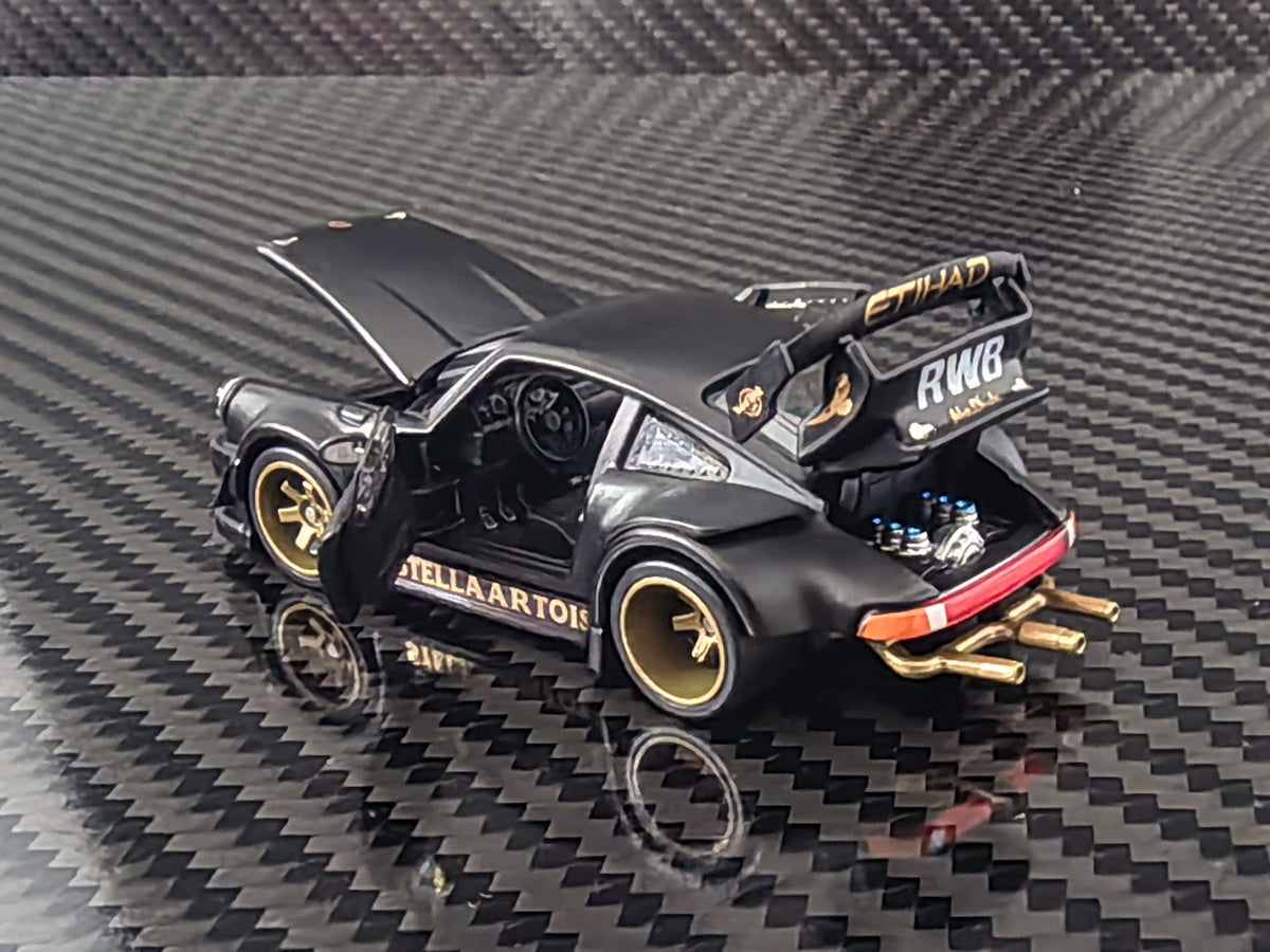 HG Model 1:64 RWB 930 Stella Artois Matte Black diecast model featuring opening doors, front hood and rear engine cover, detailed engine bay, gold wheels, widebody kit, large RWB rear wing and gold exhaust pipes, rear three-quarter view.