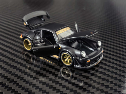 HG Model 1:64 RWB 930 Stella Artois Matte Black diecast model featuring opening front hood, side door and rear engine cover, gold wheels, widebody kit and detailed front bumper, front three-quarter view.