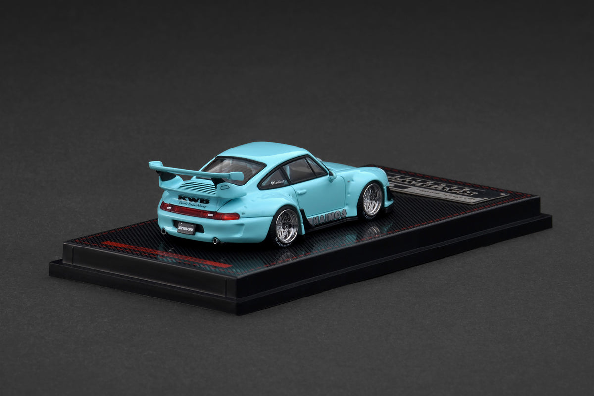 Light blue model car on a black display stand against a dark background
