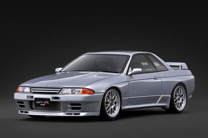 A silver Nissan GT-R R32 sports coupe shown from a three-quarter front angle on a dark studio background.