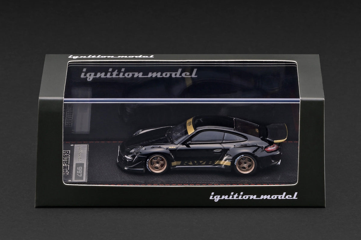 Ignition Model 1:64 RWB Porsche 997 Black IG4104 diecast model displayed in its presentation case, side view with gold accents and bronze wheels.