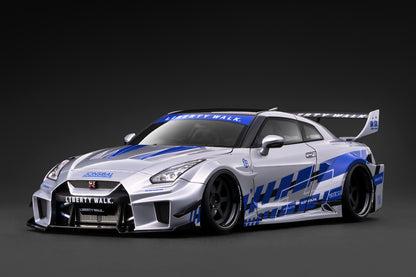 A silver Nissan GT-R Nismo race car with blue and white Liberty Walk graphics, shown from a three-quarter front angle against a dark gray studio background.