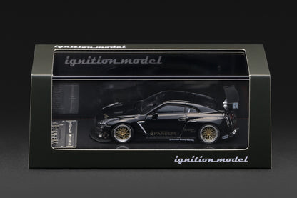 A black die-cast model car in its original display box, featuring a Nissan R35 GT-R with gold wheels and sponsor decals. The packaging is branded with 'ignition model'.