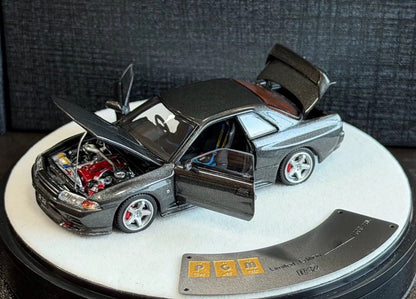 Model car with open doors on a white platform against a dark textured background