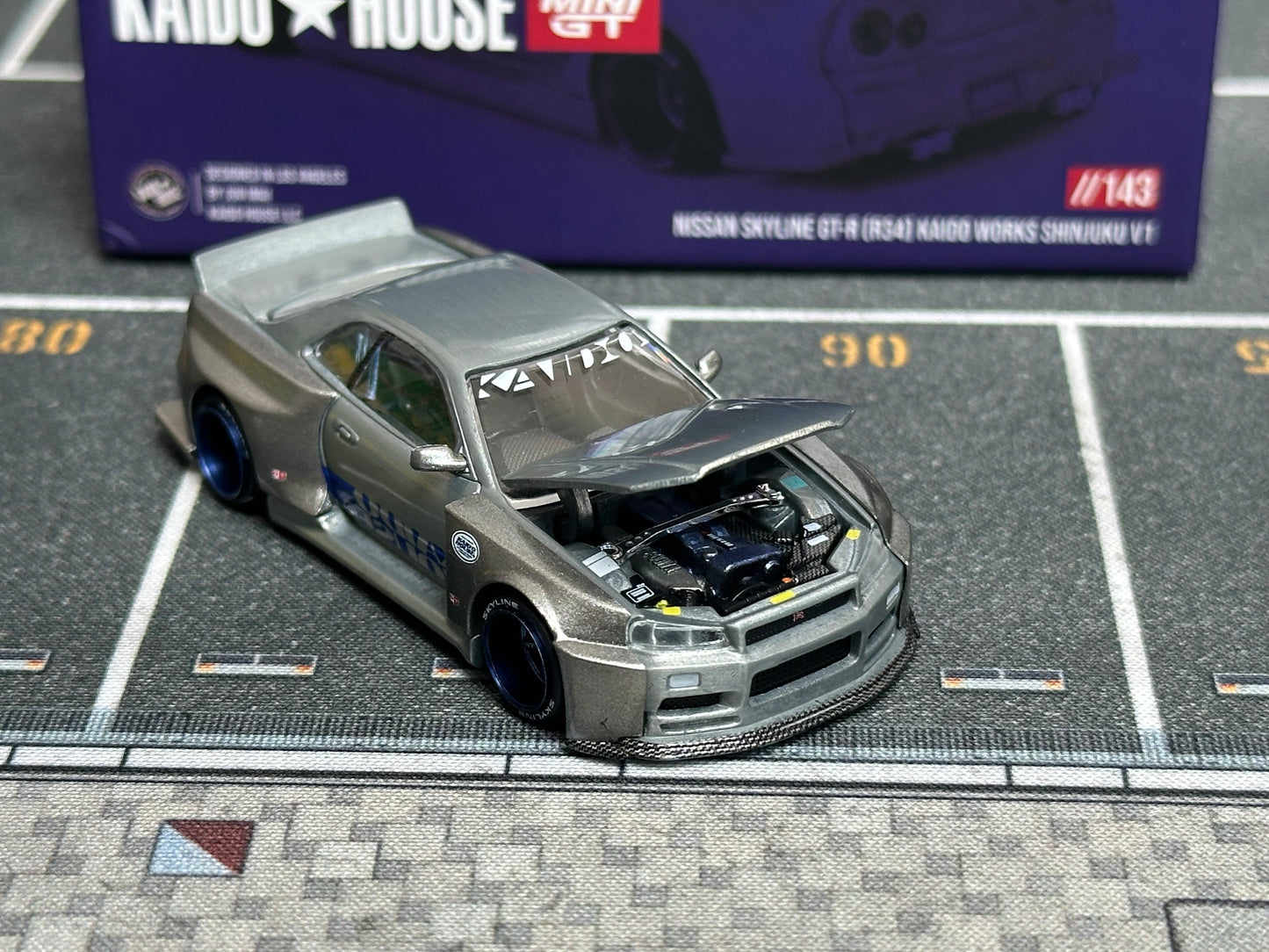 (Defective) [Chase] Kaido House x Mini GT 1:64 Nissan Skyline GT-R (R34) Kaido Works SHINJUKU V1 – Silver [Chase]