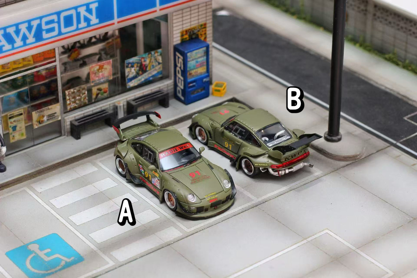 Model cars on a miniature street with a store and handicap sign in the background
